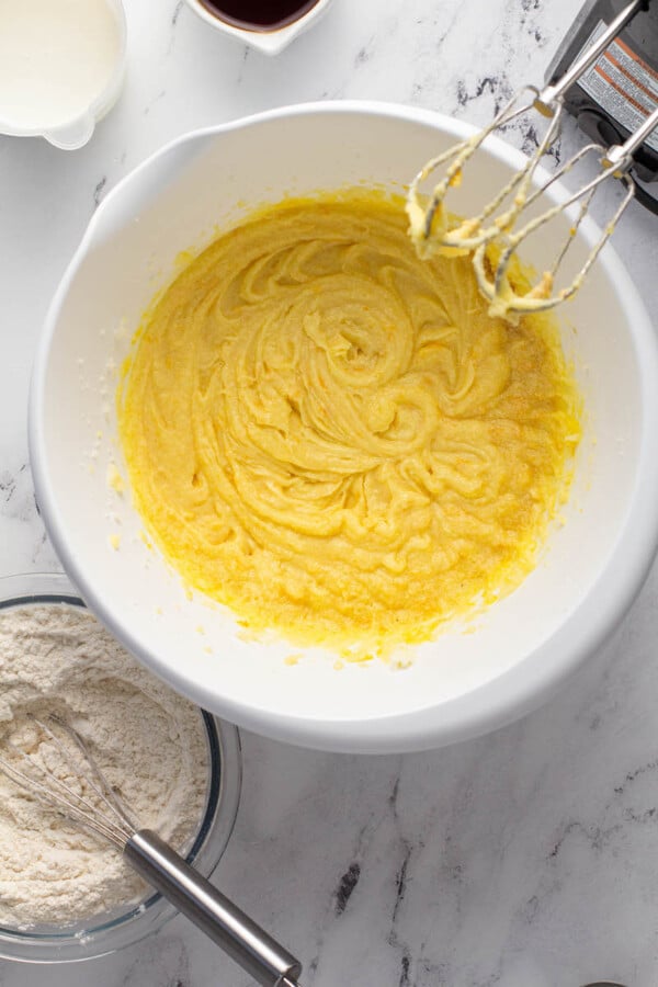 Yellow cake mix is whisked in a large white bowl.