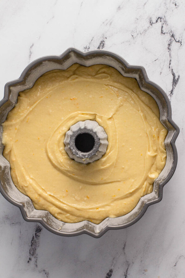 Cake batter is poured into a bundt cake pan.