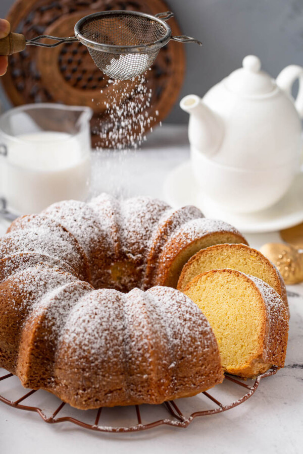 Powdered sugar is sprinkled on top of the fully baked bundt cake.