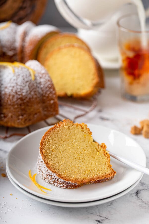A piece of bundt cake is served on a white plate.