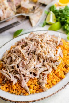 Shredded pernil is served over Spanish rice, ready to be eaten.