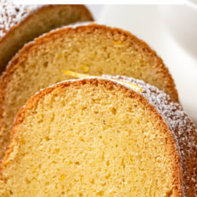 Up close image of rum bundt cake sliced into pieces with powdered sugar on top.