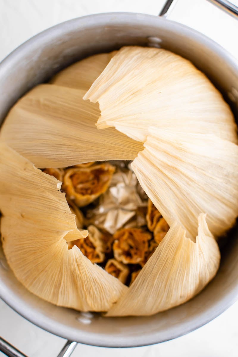 Pot of tamales lined with corn husks.