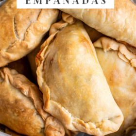 Overhead image of homemade beef empanadas stacked on top of each other.