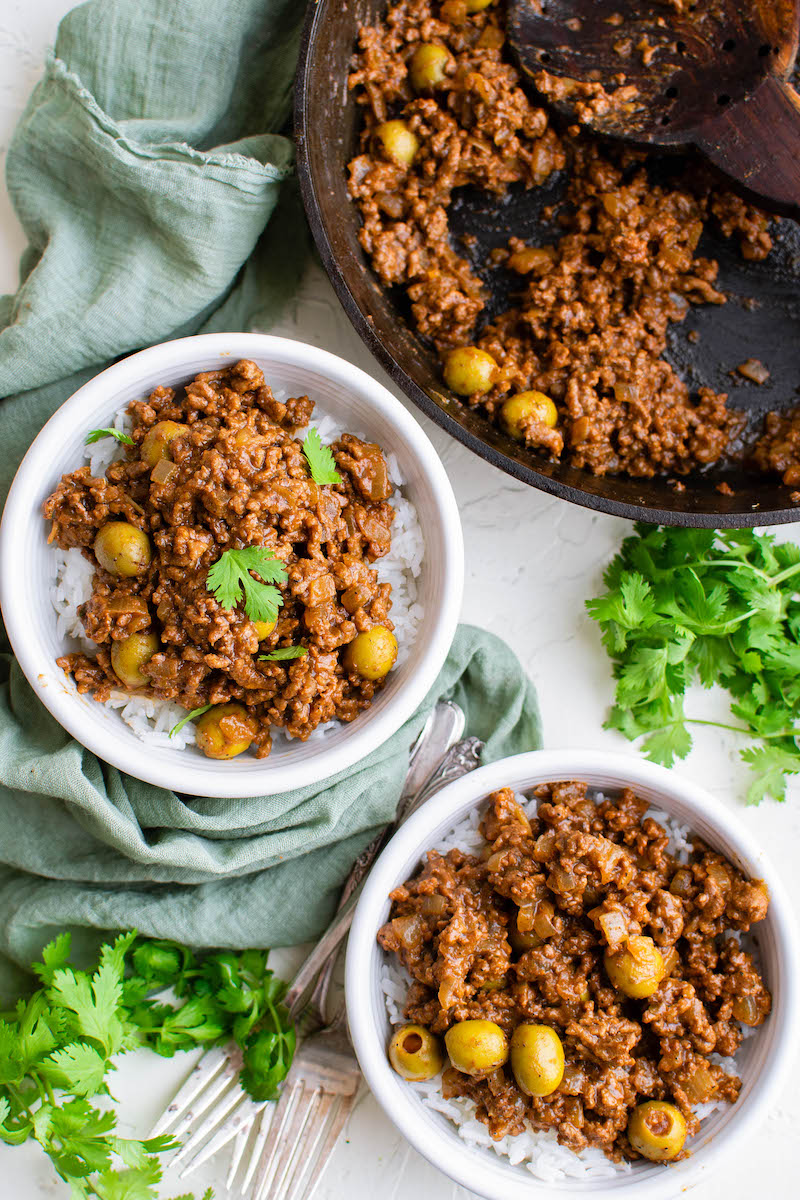 Two bowls of beef picadillo with olives.