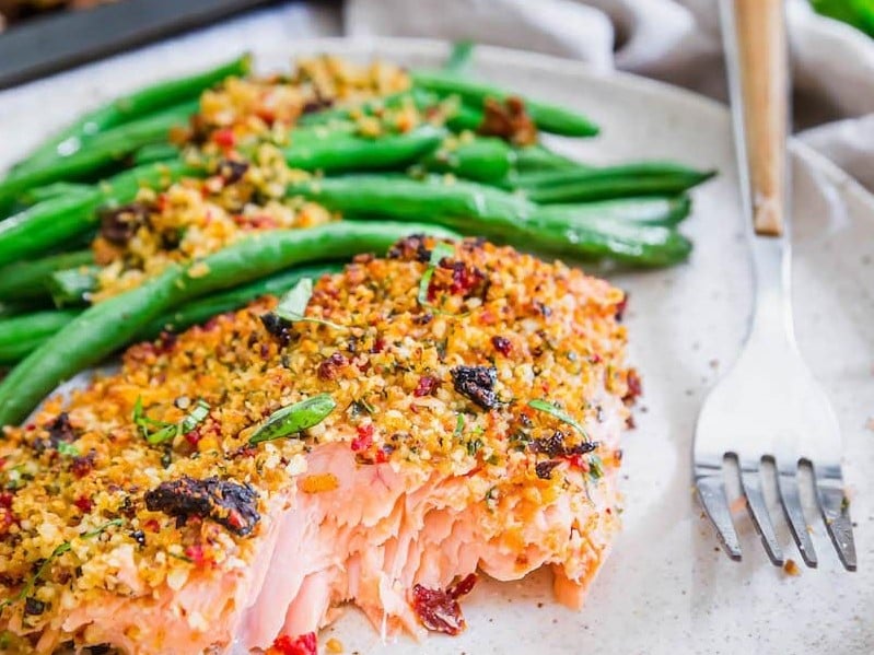 A serving of Sun-Dried Tomato Parmesan Crusted Salmon with Green Beans on a plate
