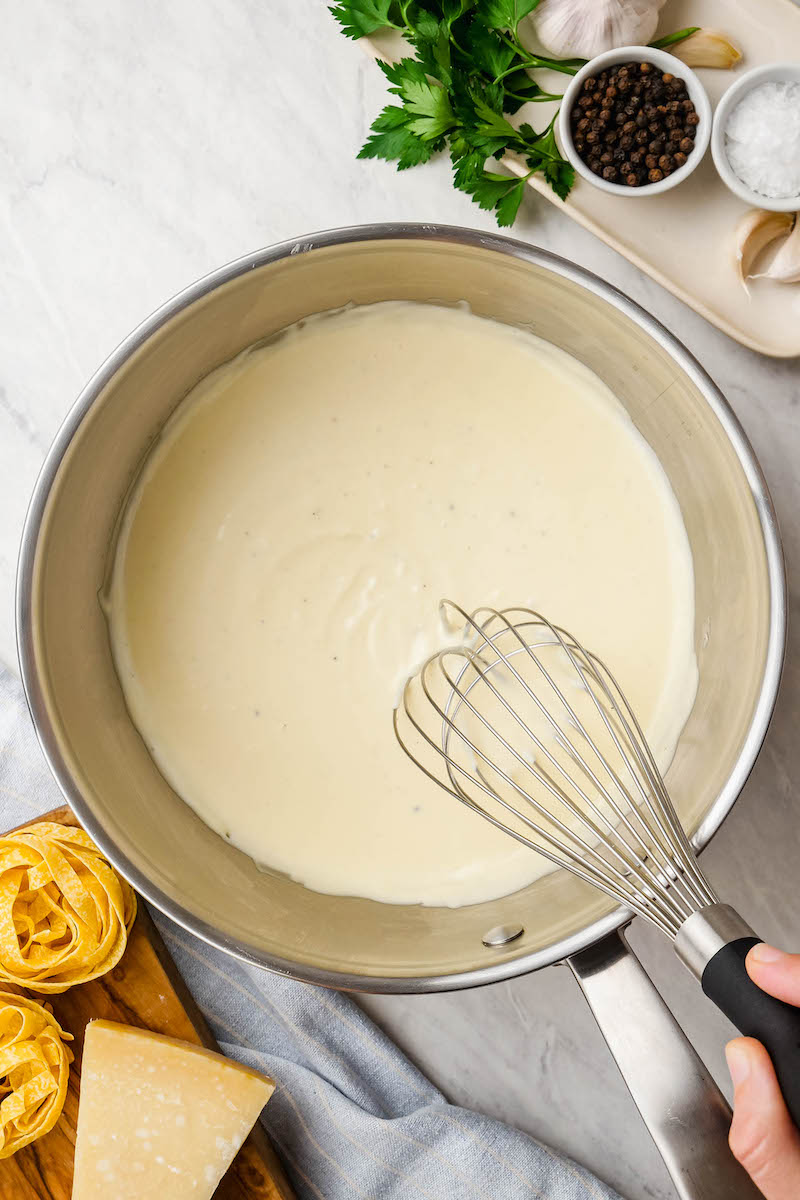 Whisk in a saucepan of alfredo sauce.