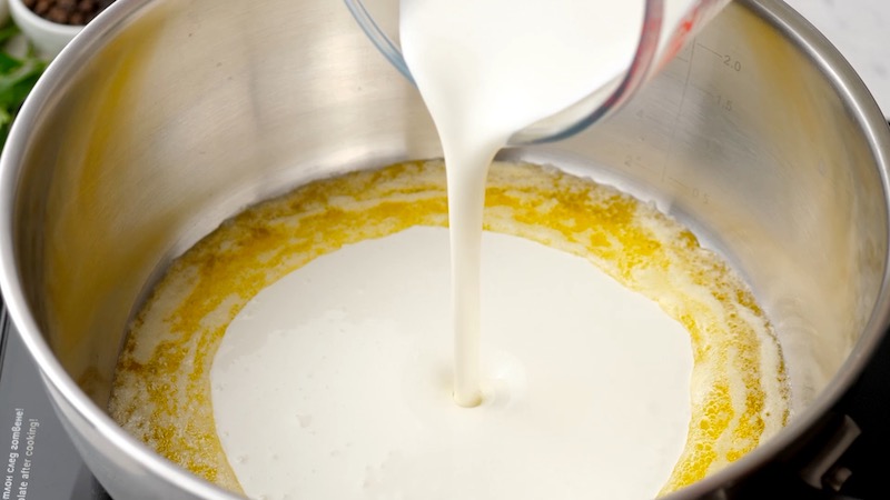 Cream being poured into a skillet with butter melted in it.