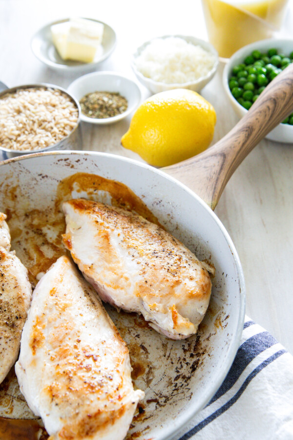 Browned chicken breasts in a pan.