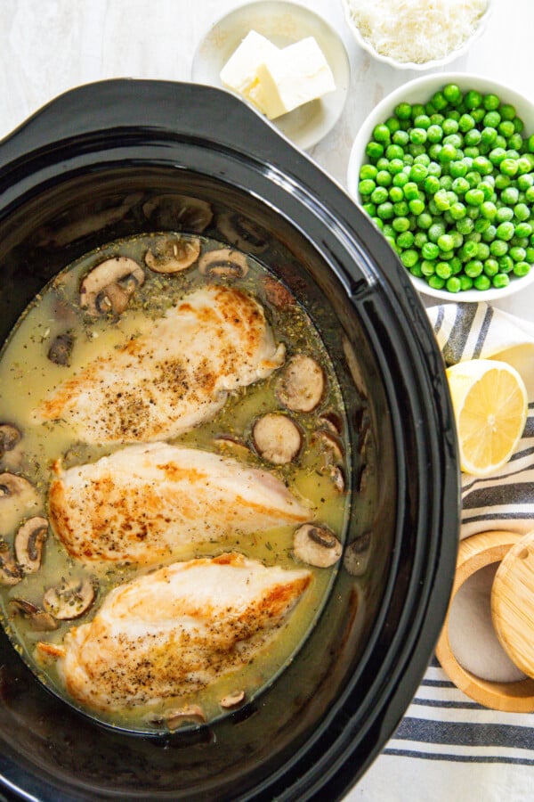 Chicken breasts and mushrooms in a crockpot.