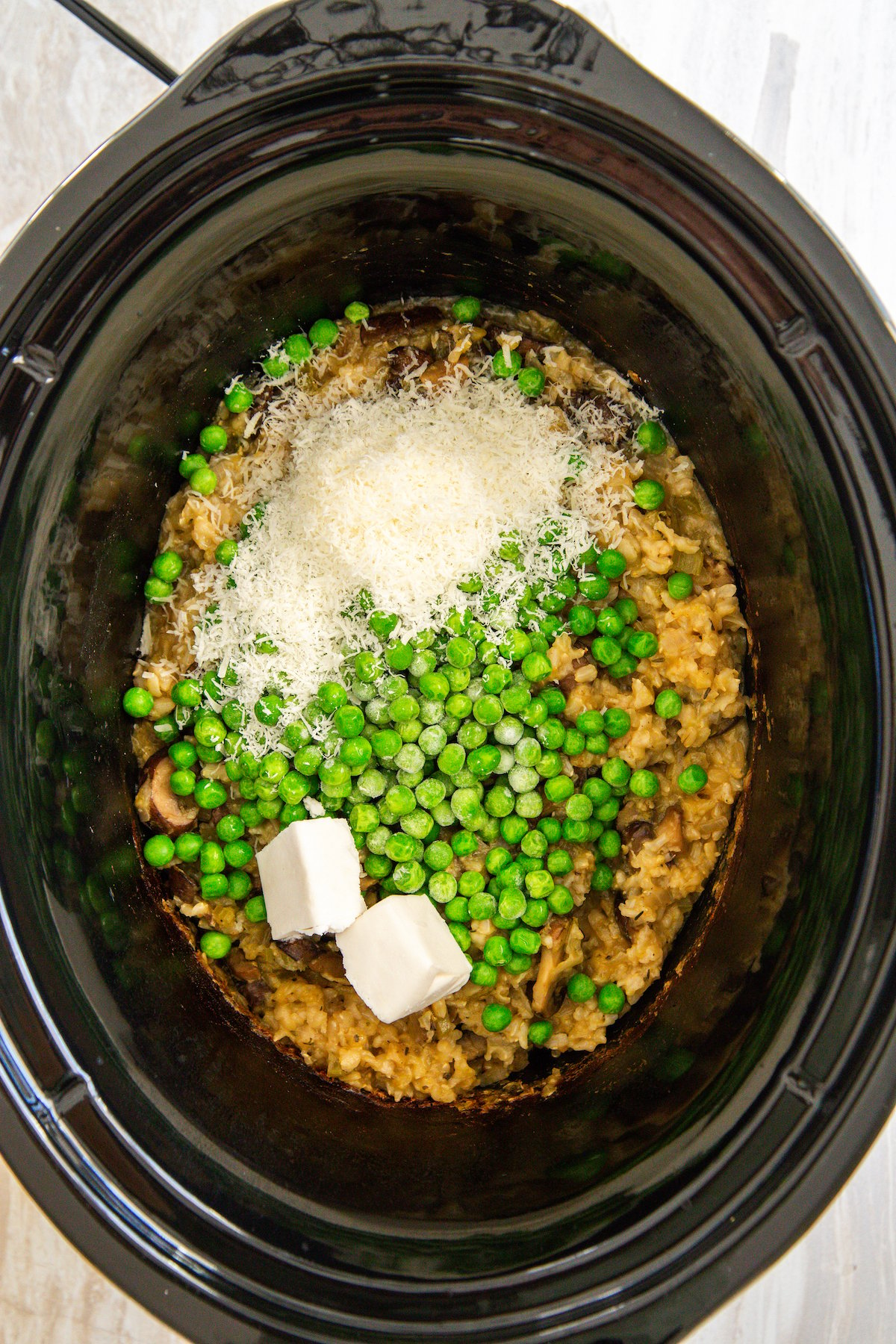 Peas, parmesan, and butter in a crockpot.