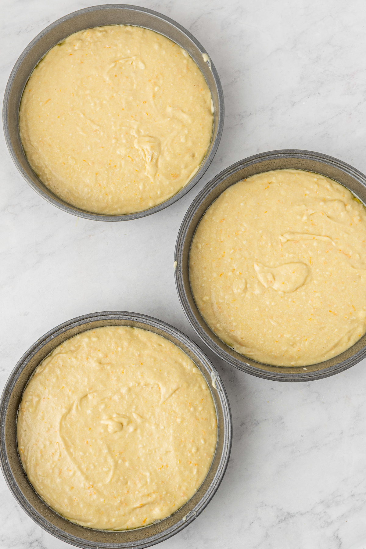 Cake batter in 3 8-inch pans.