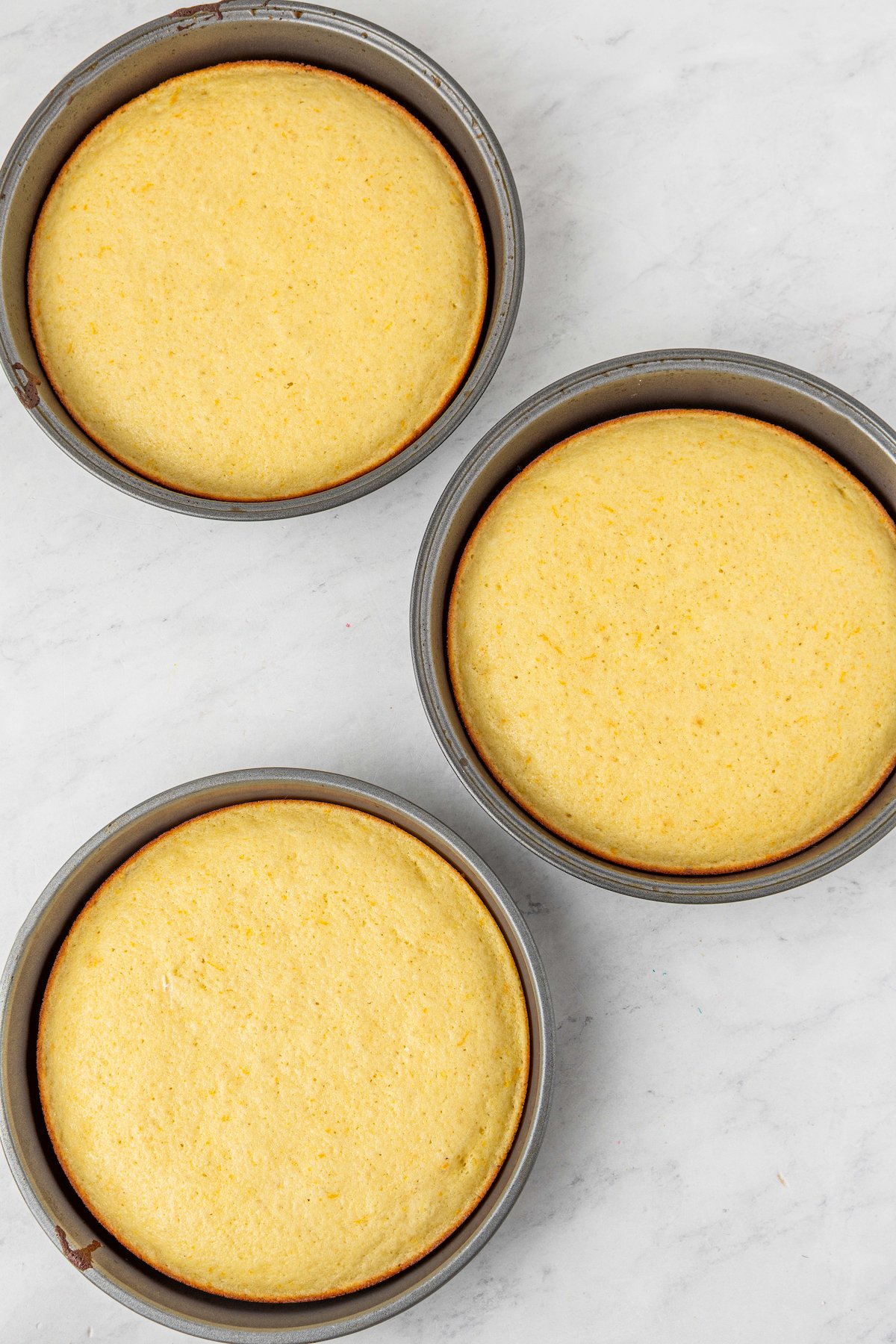 3 baked cakes in pans.