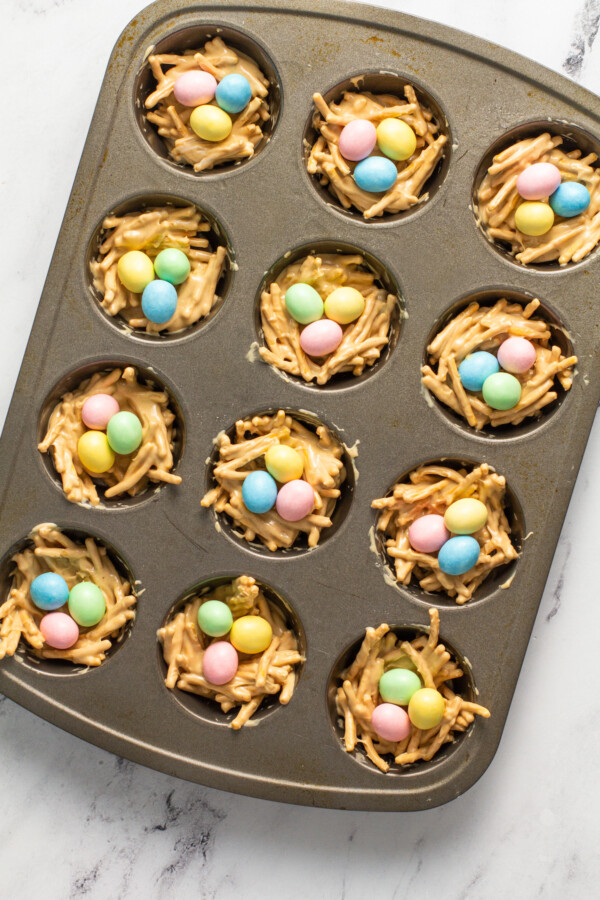 Pastel candy eggs are placed in the middles of the haystacks.