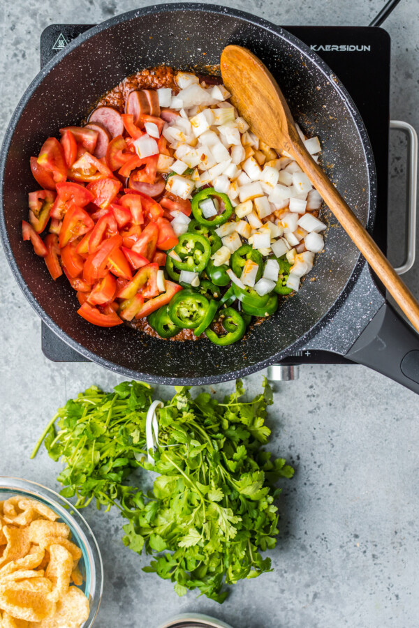 Diced tomatoes, jalapenos, and onions in a pan.
