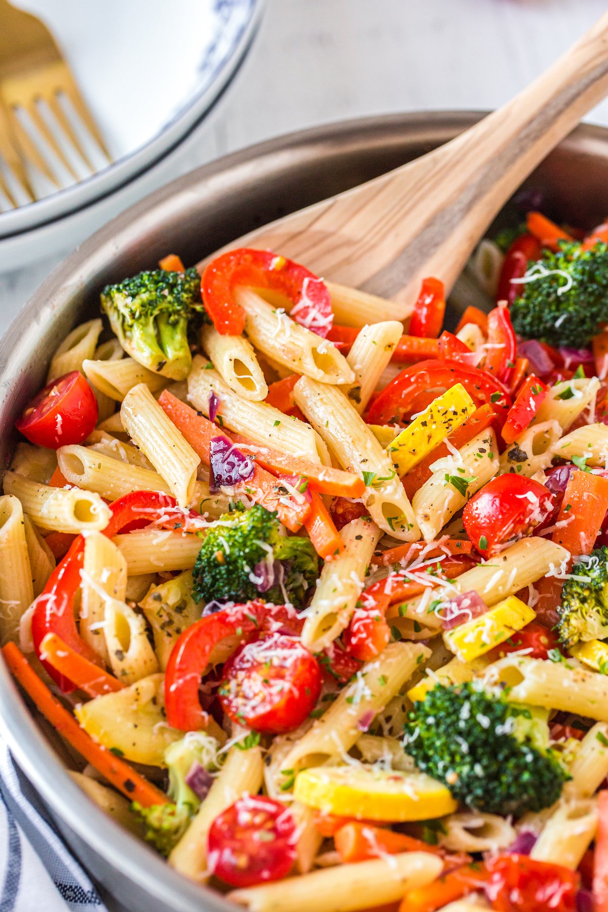 Pasta primavera in a pan with cheese.
