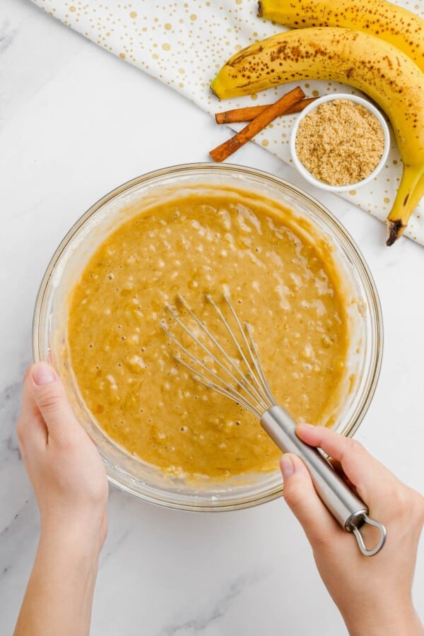 Banana bread batter mixed in a glass bowl.