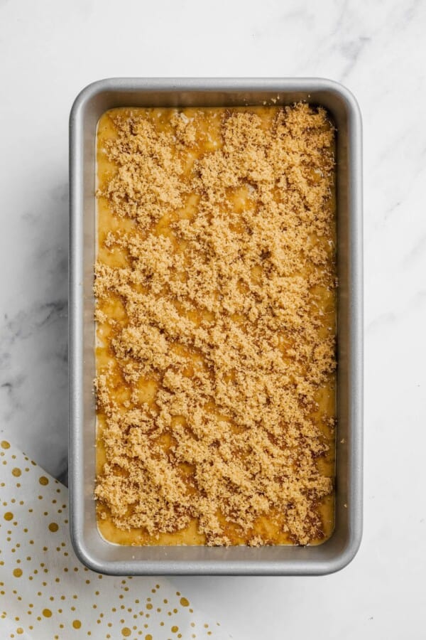 Banana bread batter with brown sugar topping in a loaf pan.