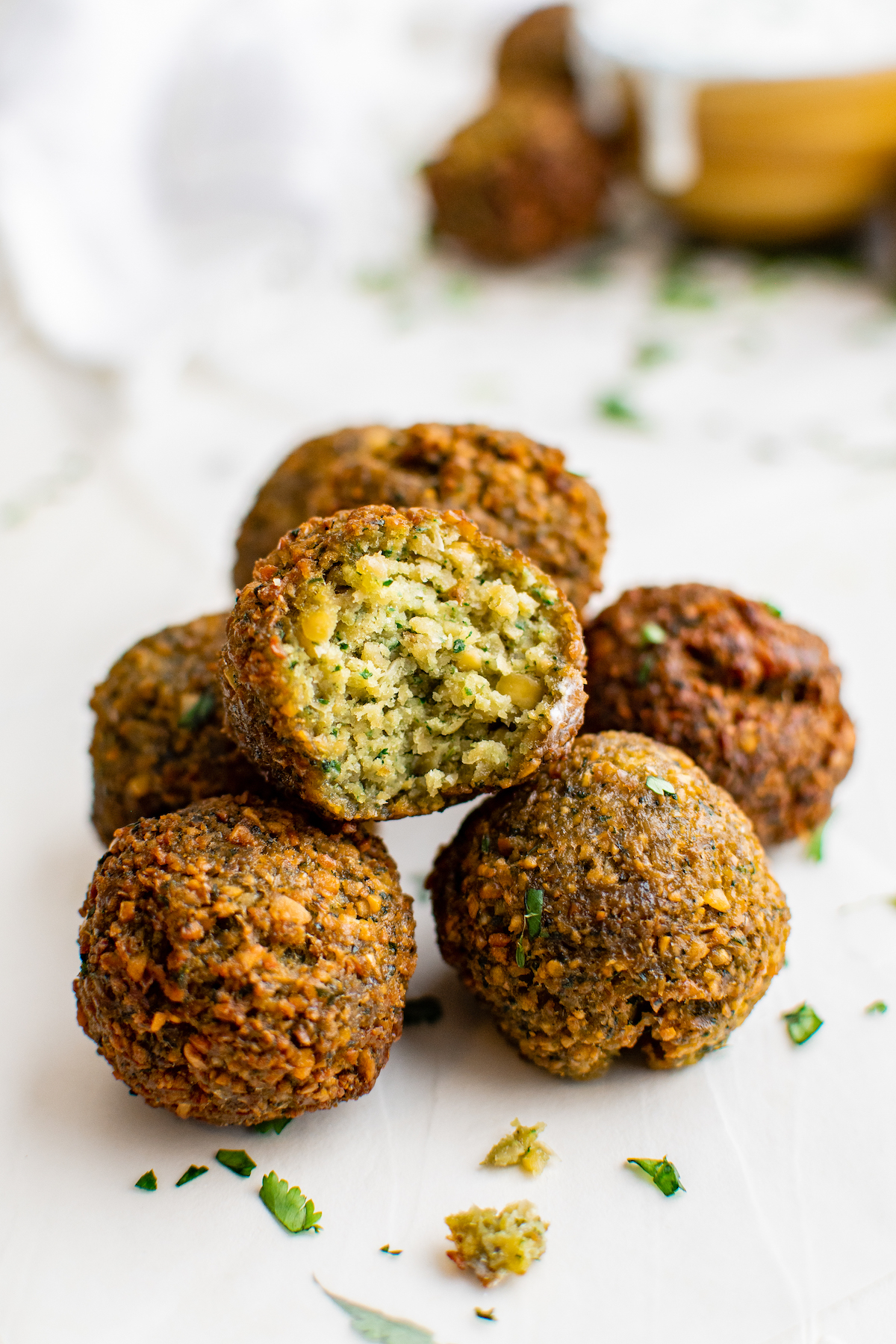 Falafel ball in a pile with a bite taken out of it.
