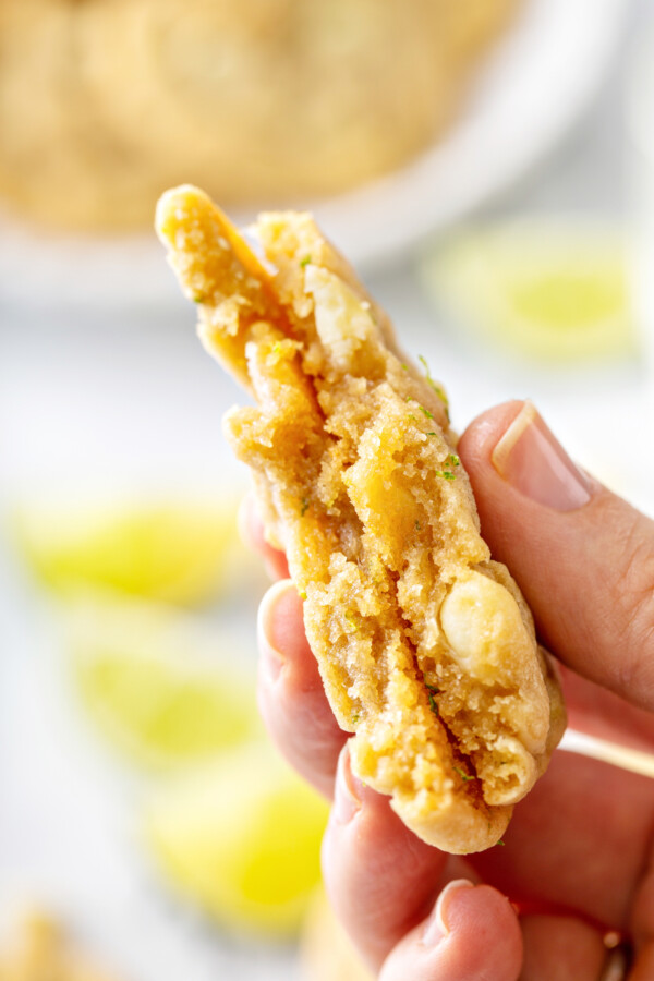 A key lime cookie is being held in someone's hand.