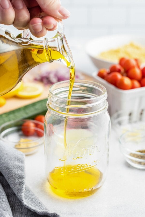 Olive oil poured into a jar.