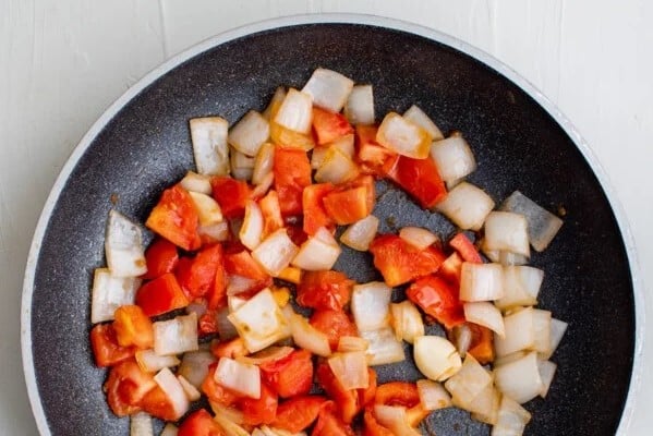 Diced tomatoes, onions, and garlic in a skillet