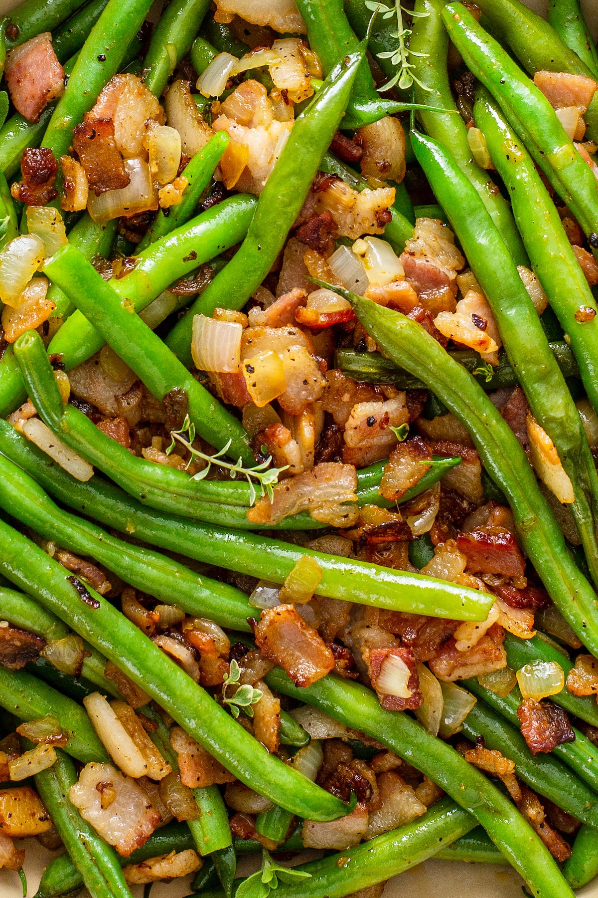 Cooked green beans with chopped cooked bacon and onions mixed in.