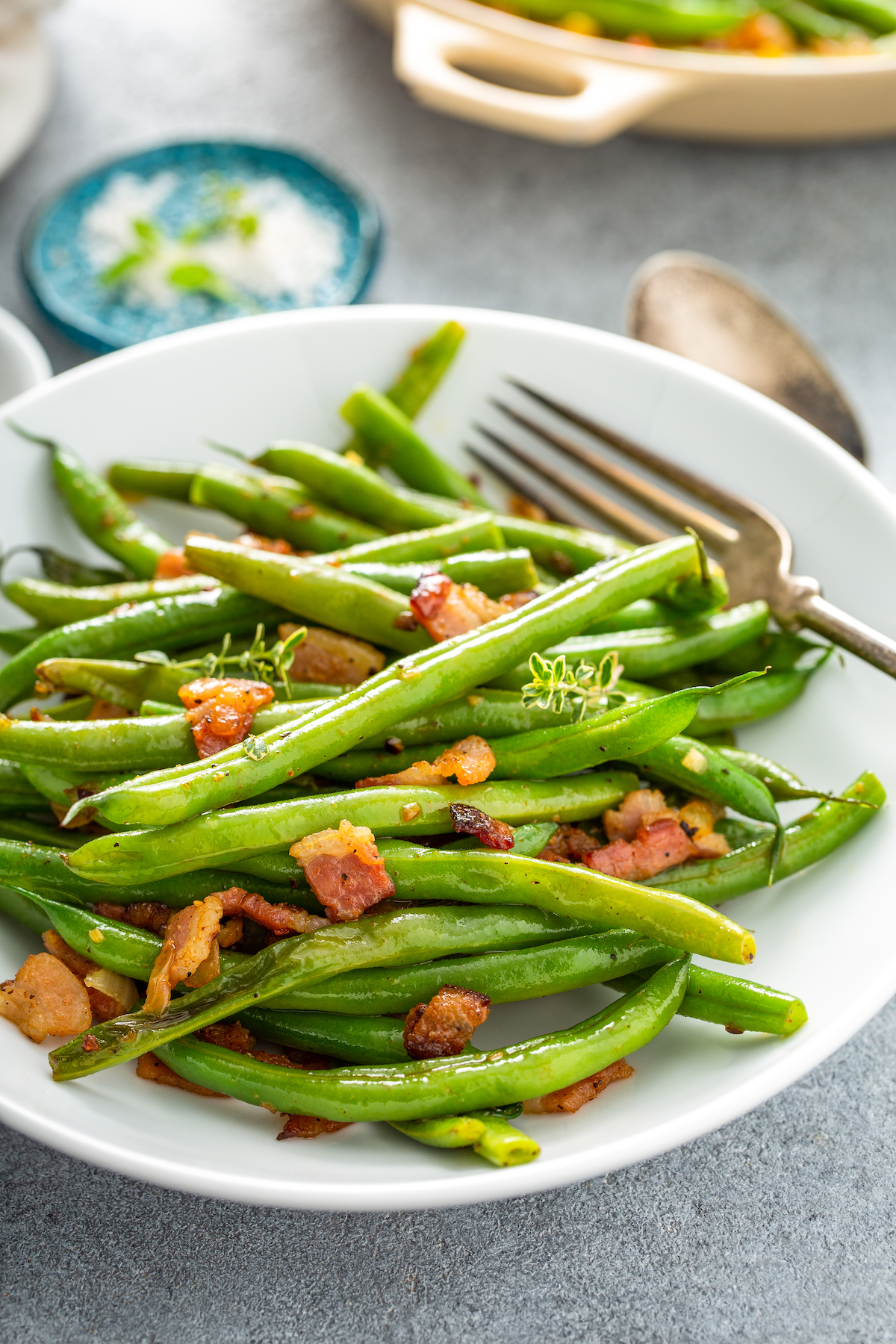 Serving of green beans with bacon bits.