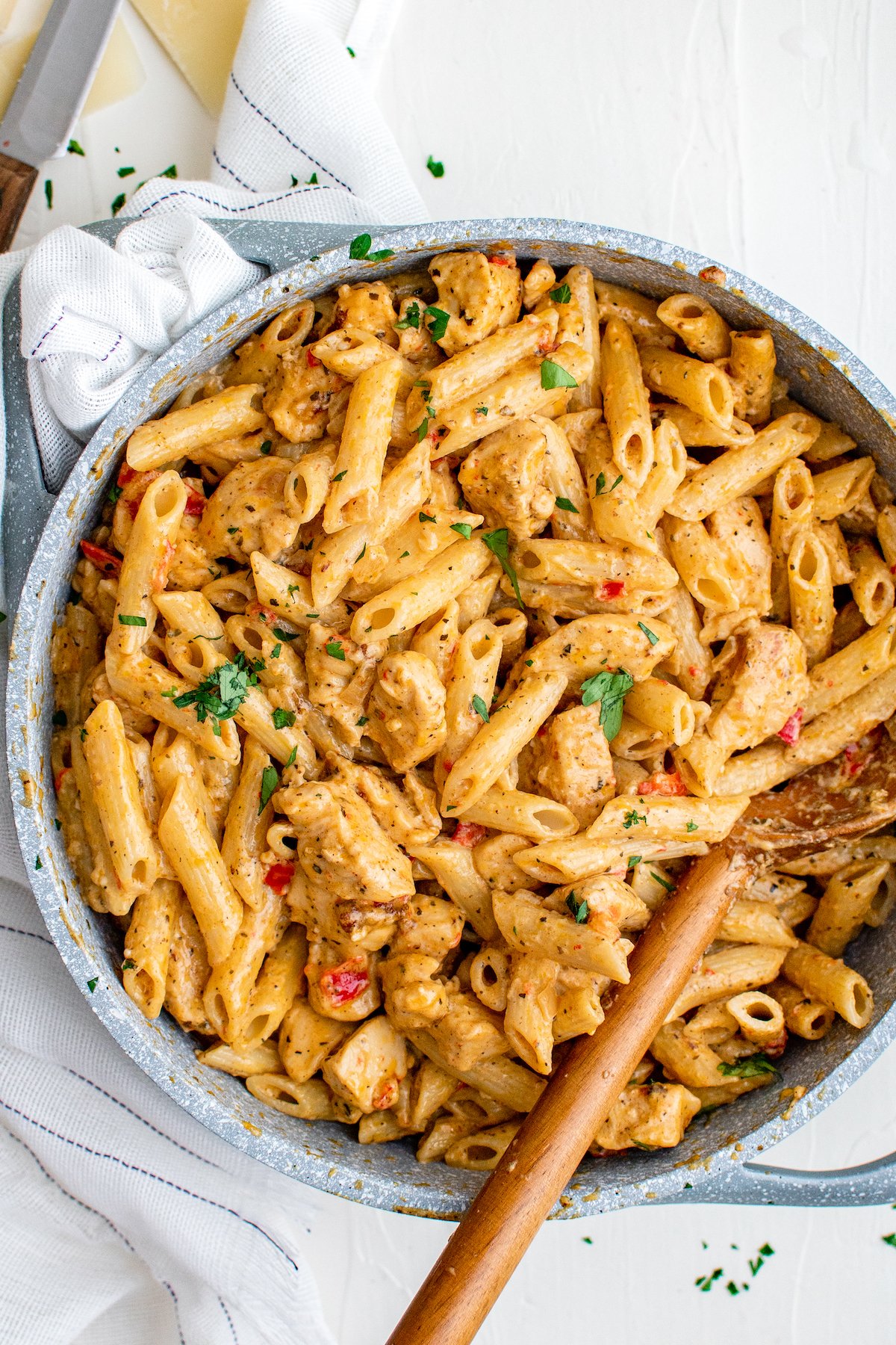 A pot of creamy pasta with chicken and peppers.