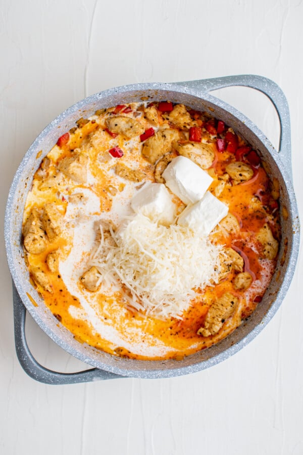Cream cheese and parmesan in a pan with chicken.