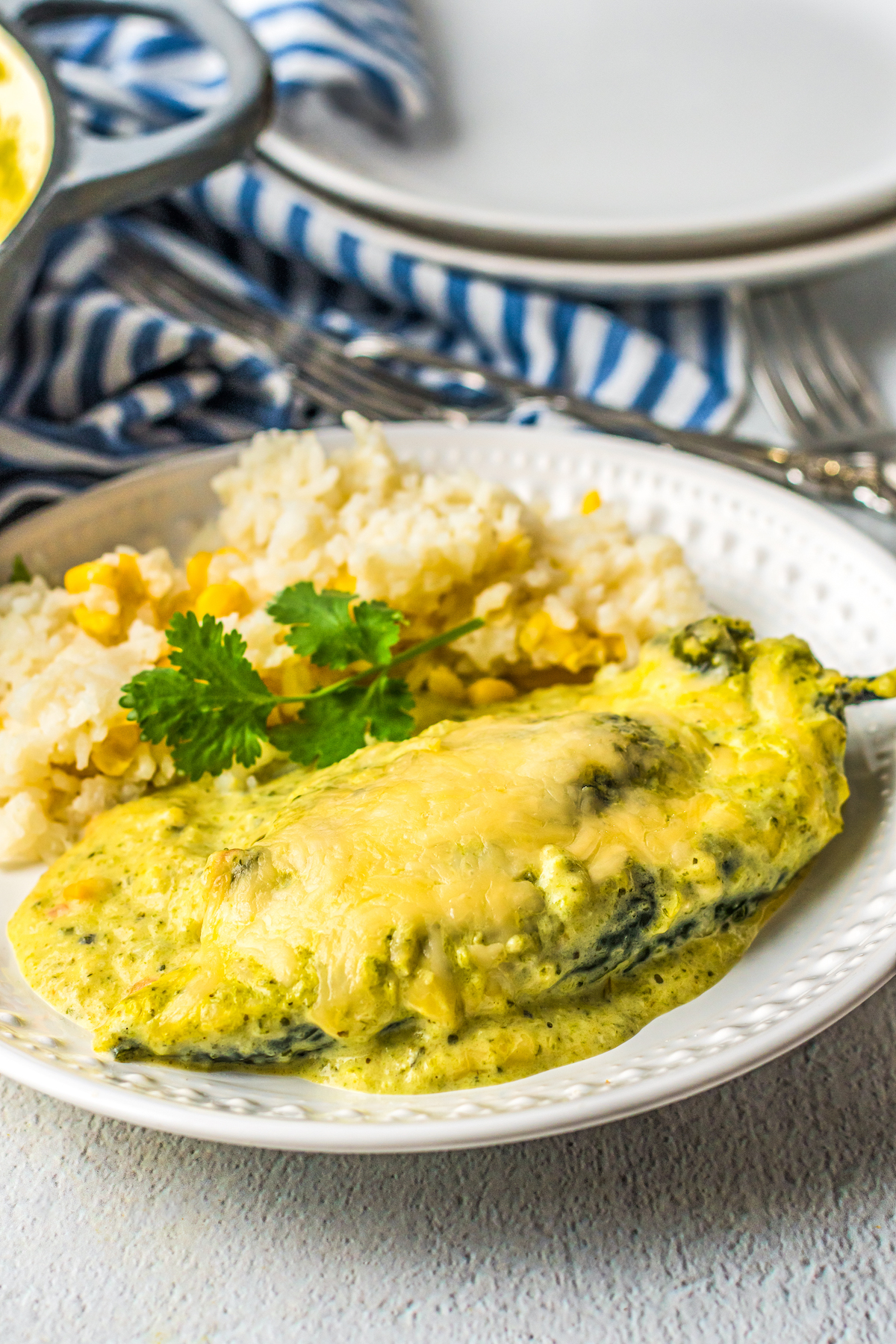 Chile rellenos on a plate with sauce.