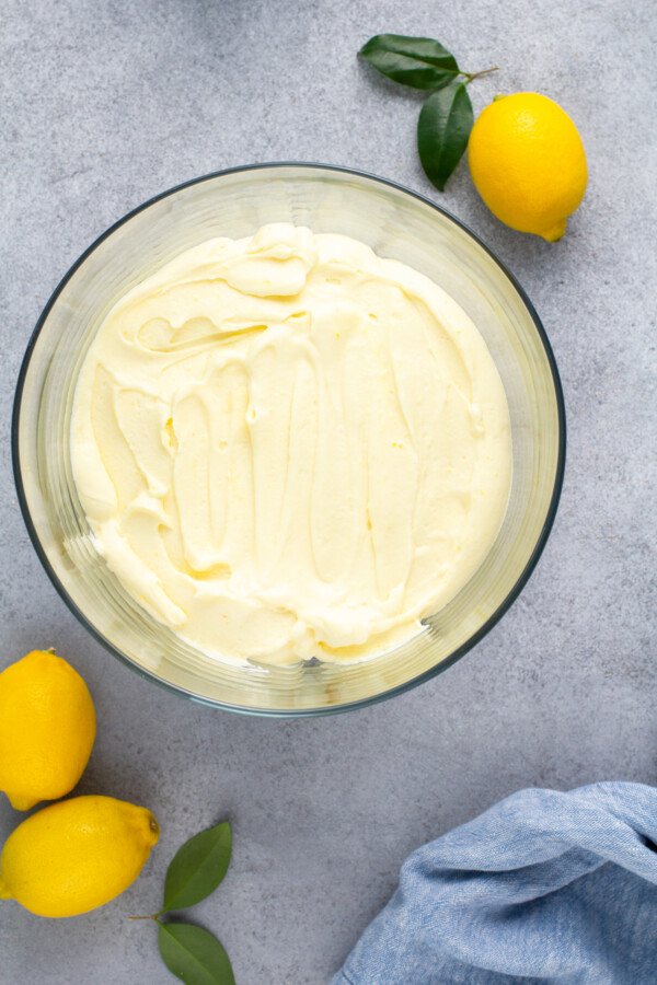 Whip cream spread around a glass trifle bowl.