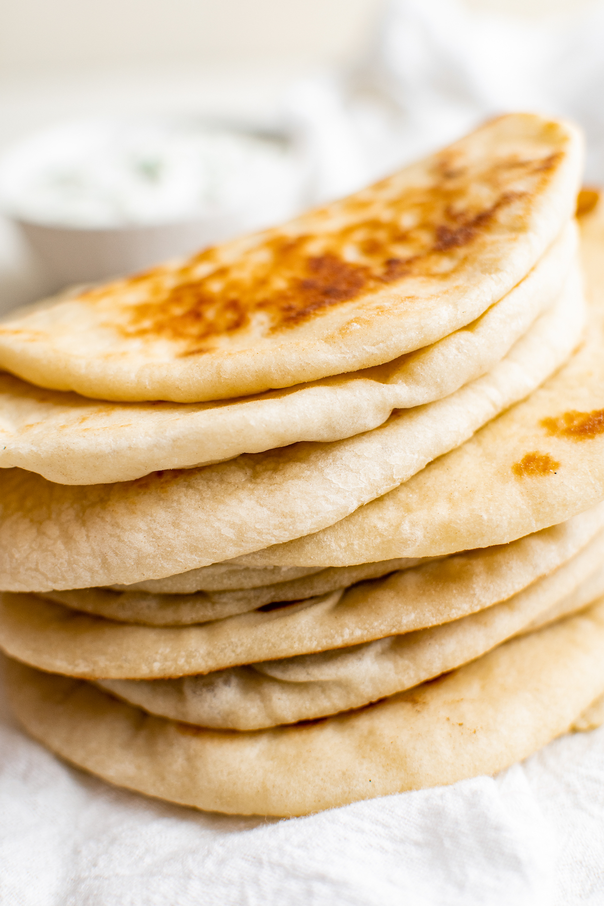 Loaves of homemade pita bread in a stack.