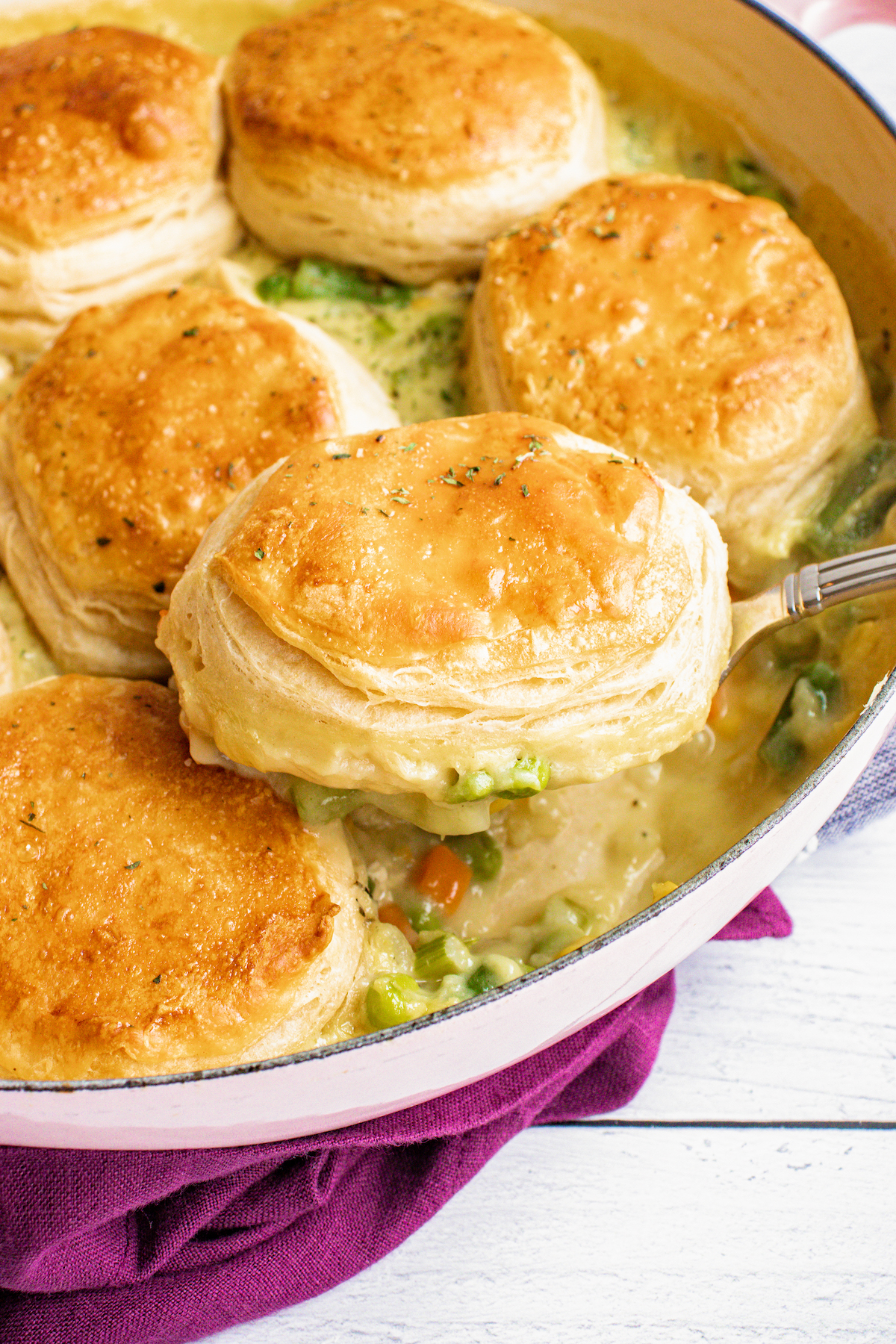 Chicken pot pie with biscuits with a serving spoon.