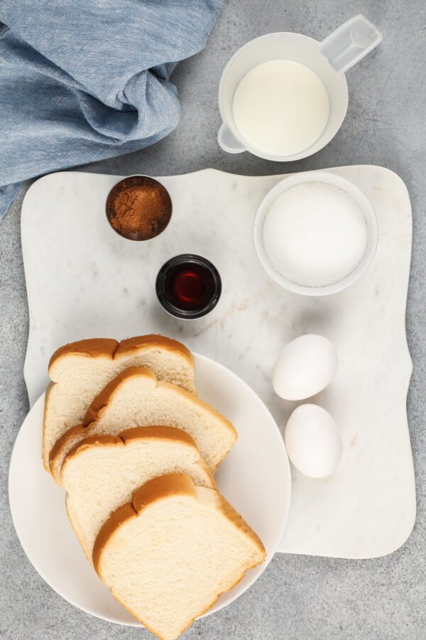 The ingredients for French toast sticks are on a white surface. 