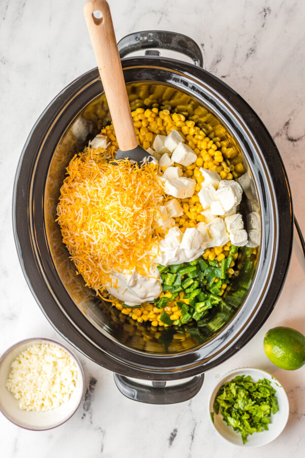 Cheese, cream cheese, and corn in a crockpot.