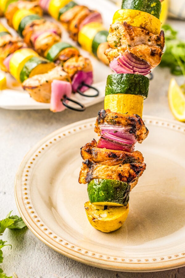 Chicken skewer being emptied onto a plate.