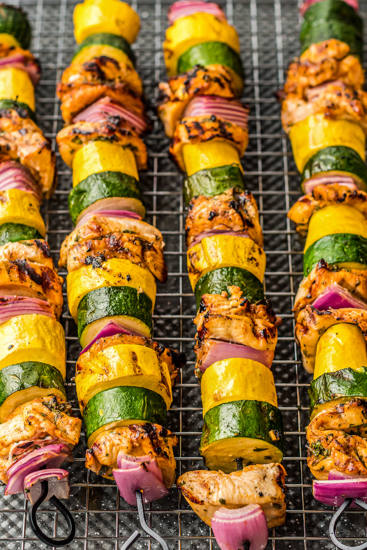 Grilled chicken shish kabobs on a cooling rack.