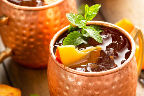 Two copper mugs are garnished and filled to the brim. 