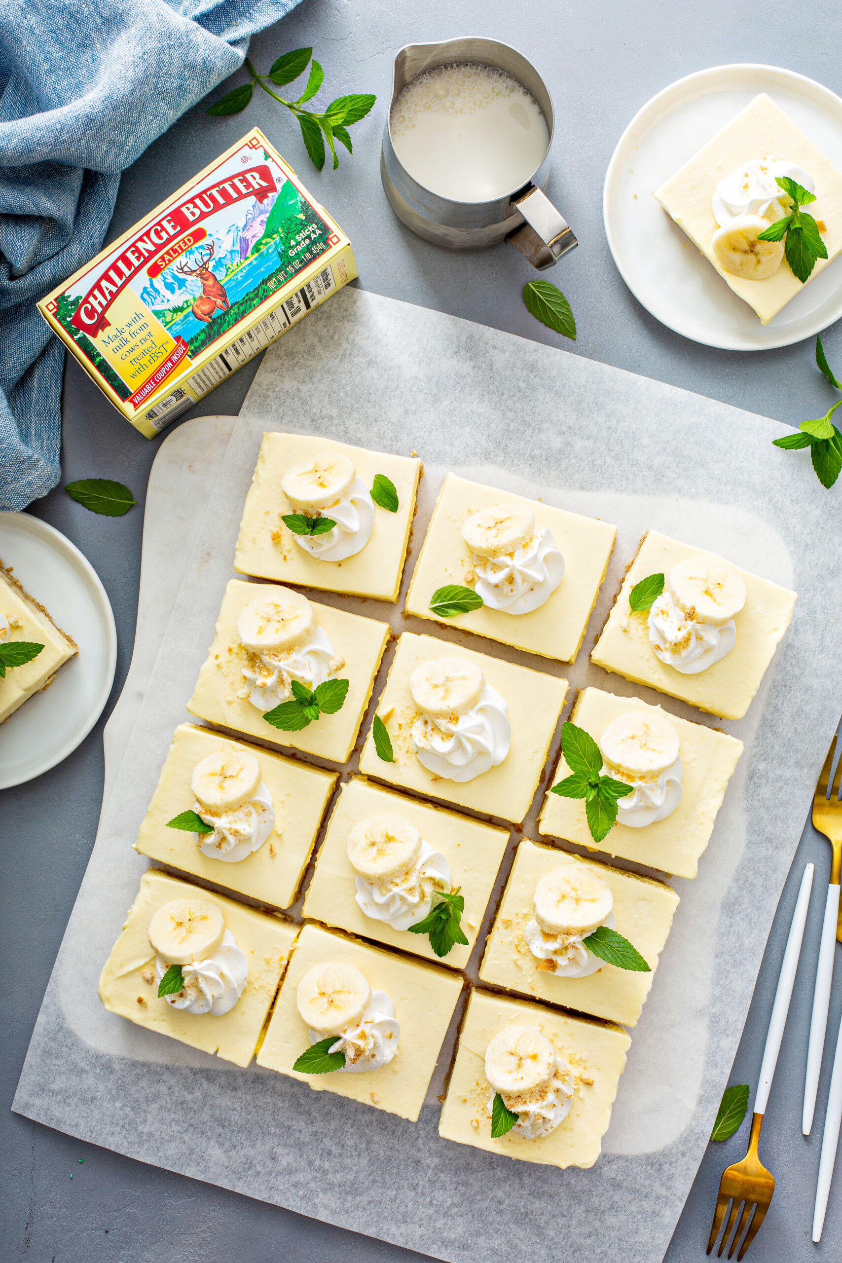 Overhead image of Banana pudding bars are garnished with banana slices, whipped cream and mint sprigs.