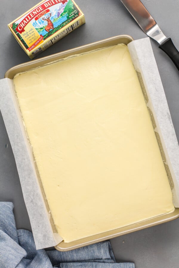 Pudding is spread in an even layer in a baking sheet.