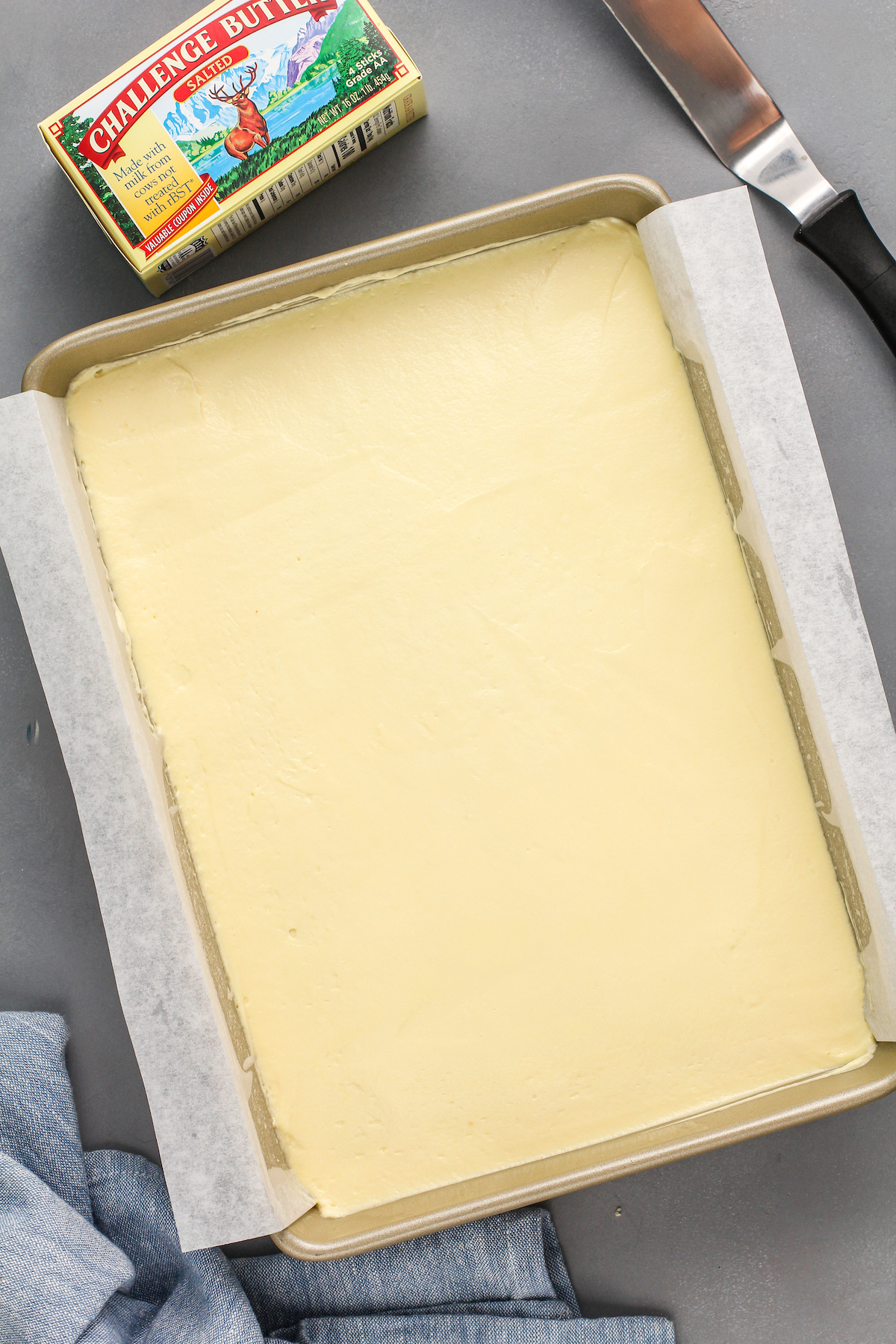 Pudding is spread in an even layer in a baking sheet. 