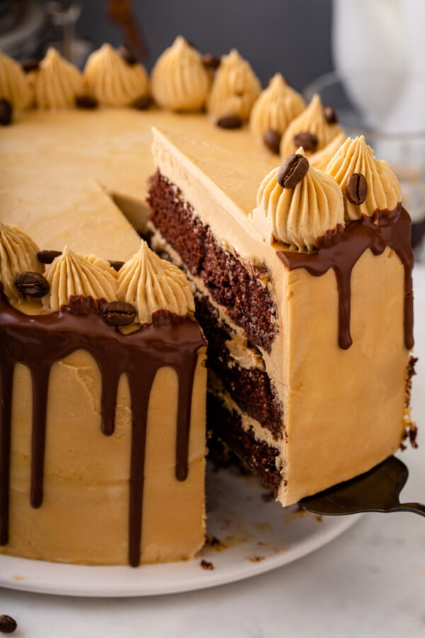 A slice of cake is being removed from the cake itself. 