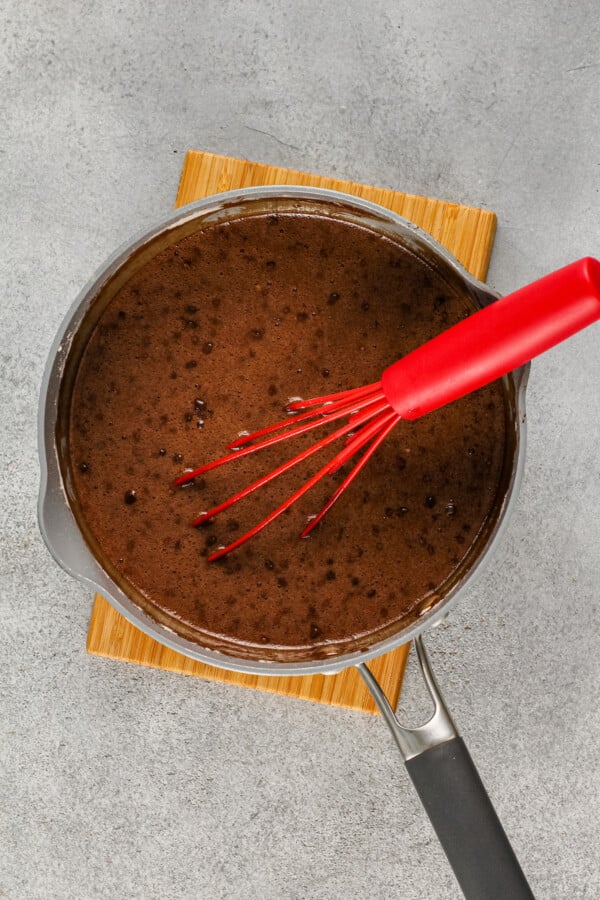 Wet ingredients have been mixed together in a metal pot. 