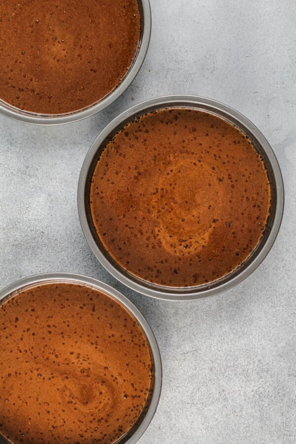 Three cake pans are filled with uncooked batter. 