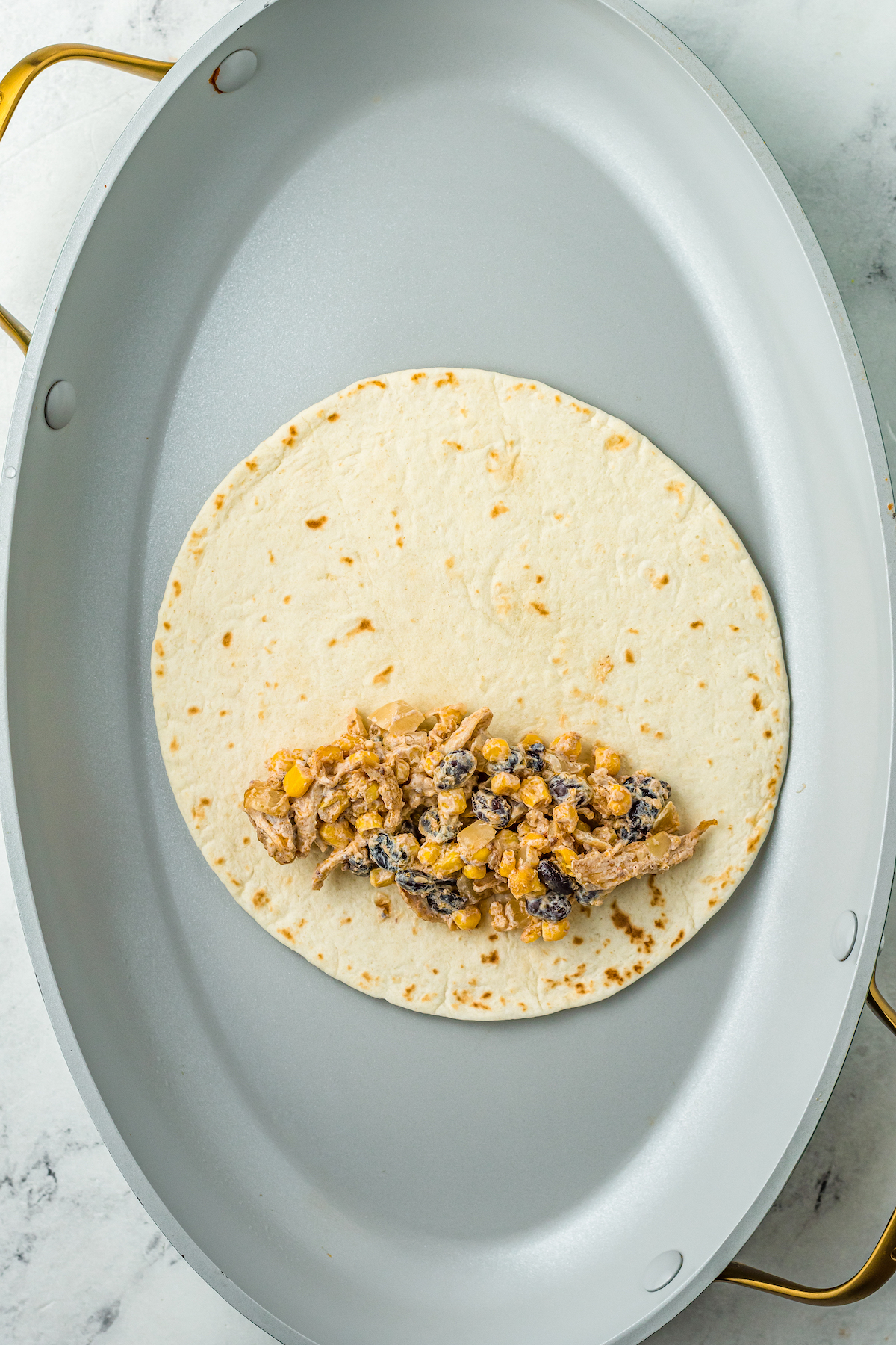Chicken filling on the edge of a tortilla.