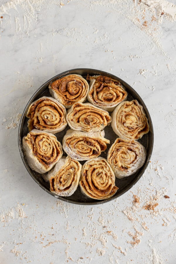 Unbaked cacon cinnamon rolls in a round pan.