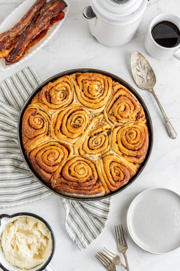A pan filled with baked bacon cinnamon rolls.