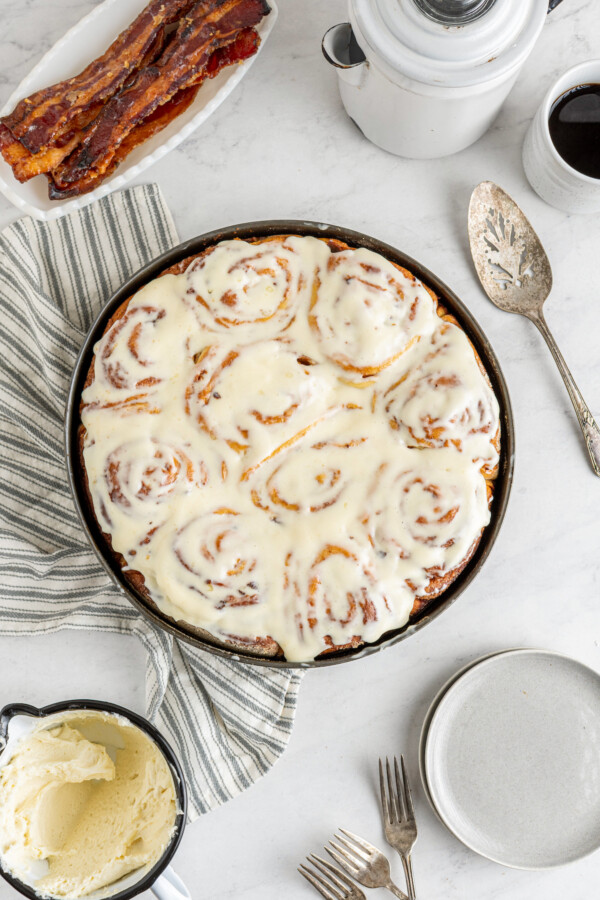 Cinnamon buns with cream cheese icing on top.