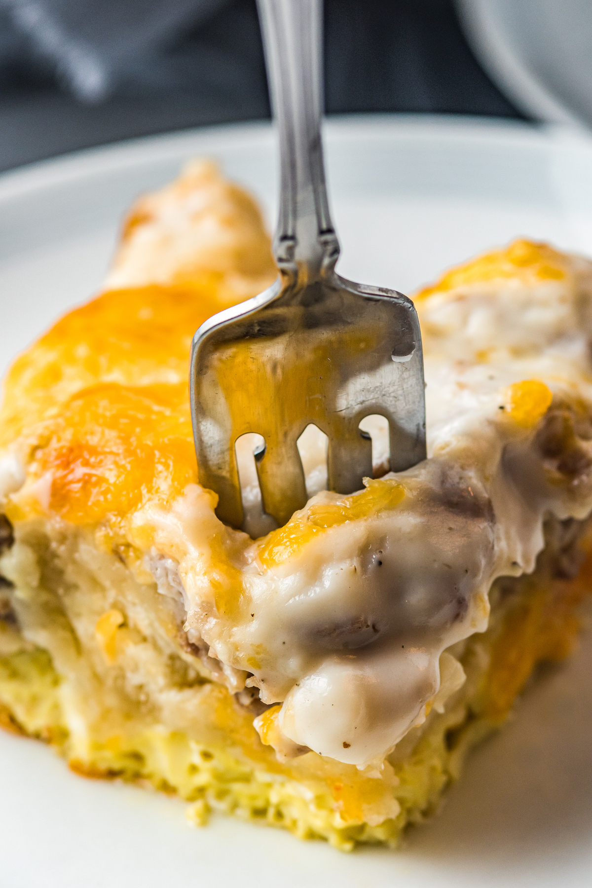 A plate of cheesy biscuits and gravy casserole.